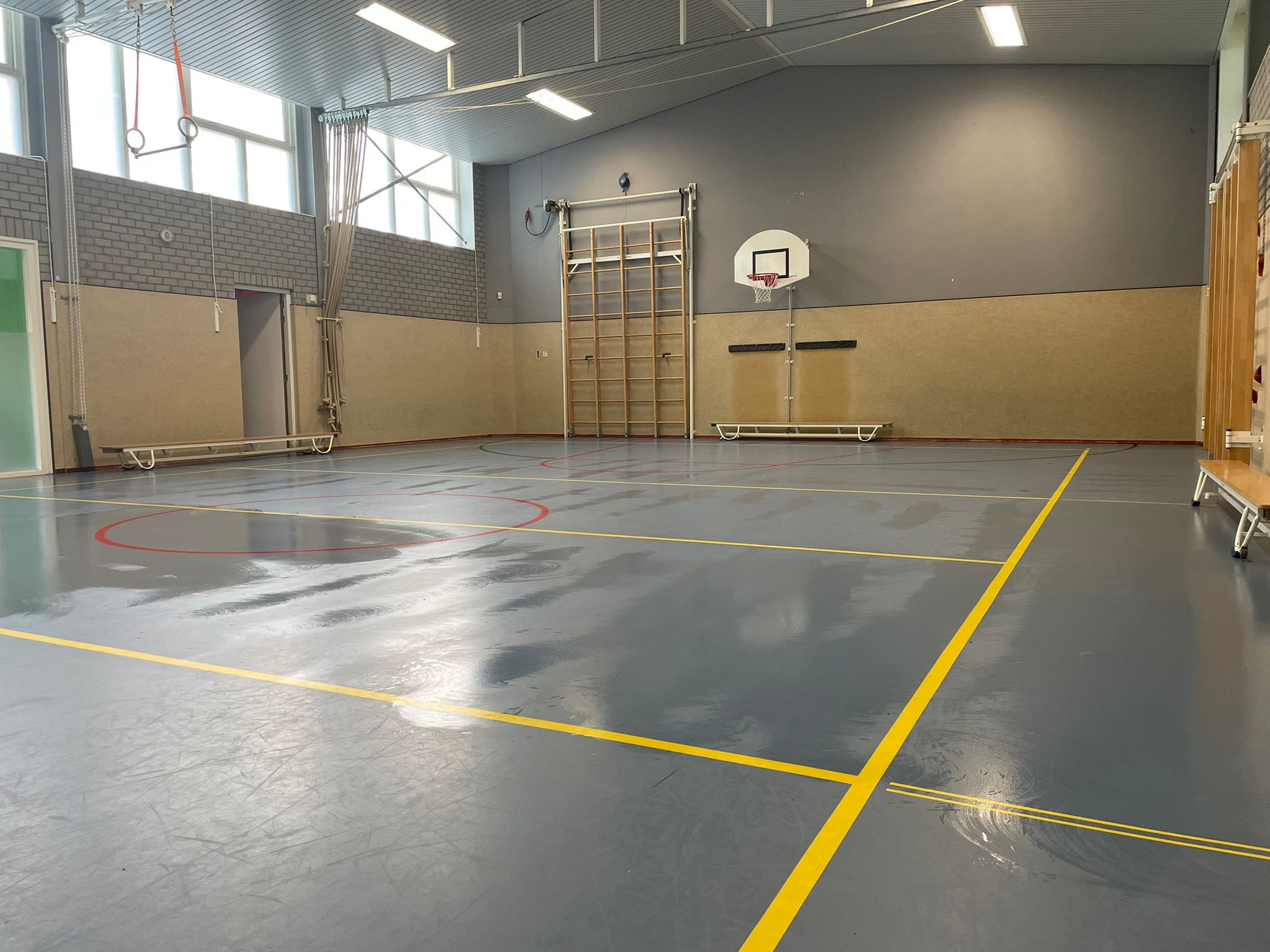 Gereinigde sportvloer en nevenruimte in gymzaal